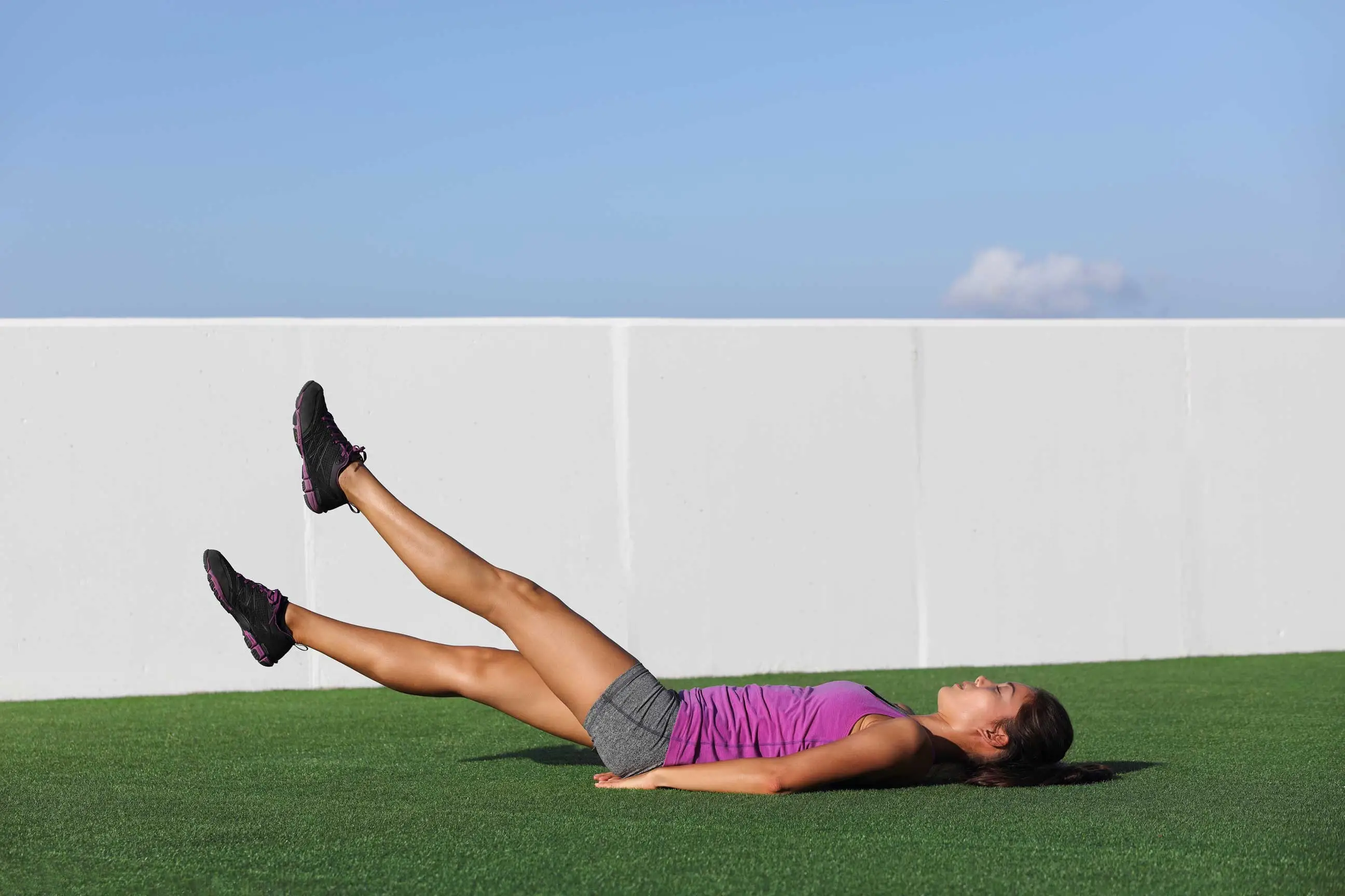 Frau trainiert Beine und Bauch mit Flutter Kicks